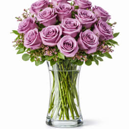Lavender roses arranged in a clear glass vase