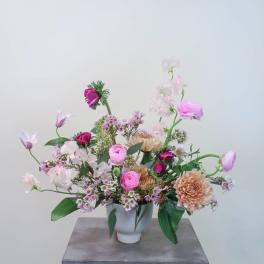 Pink and peach mixed flower arrangement in a white vase