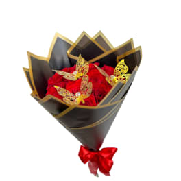 Bouquet of red roses wrapped in black paper with gold trim and butterfly decorations