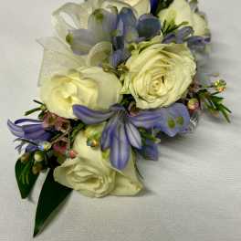 White and lavender floral corsage with ribbon and rhinestone accents