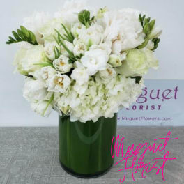 White floral arrangement in a green glass vase