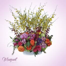Colorful mixed flower arrangement in a low white container