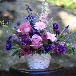 Basket arrangement of pink and purple flowers