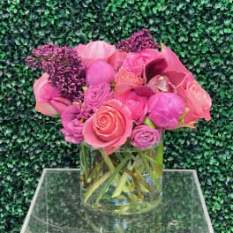 Pink and purple flower arrangement in a clear glass vase