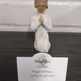 Small praying figurine with a card reading Prayer of Peace