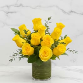 Yellow roses arranged in a green glass vase