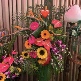 Tropical floral arrangement with sunflowers, gerbera daisies, and pink anthuriums