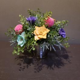 Small bouquet of colorful flowers in a black container