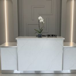 White orchid in a small square vase on a marble reception desk