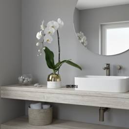 White orchid in a gold and white pot on a bathroom counter