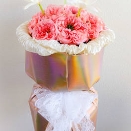 Pink roses in a metallic gift box with white flowers on top