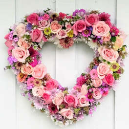 Heart-shaped floral wreath with pink roses and mixed blooms