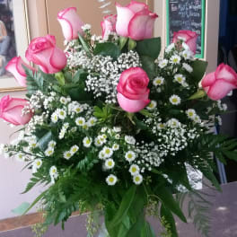 Pink roses and white daisies arranged in a glass vase