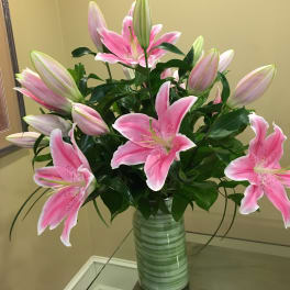 Pink lilies arranged in a striped glass vase
