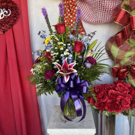 Mixed bouquet with red roses and lilies in a glass vase