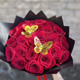 Bouquet of red roses with yellow butterfly decorations in black wrap
