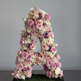 Large floral letter A covered in pink and white roses and orchids