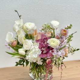 Mixed bouquet in a clear glass vase with white, pink, and peach flowers