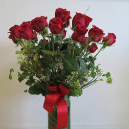 Bouquet of red roses in a glass vase with a red ribbon