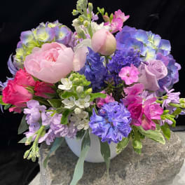 Pastel bouquet of peonies, hydrangeas, and hyacinths in a white vase