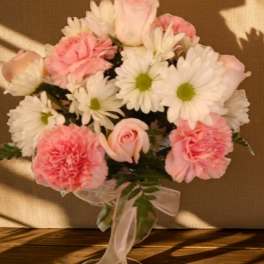 Pink and white bouquet with daisies and carnations tied with a ribbon
