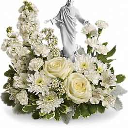 White floral arrangement with a statue of Jesus in the center