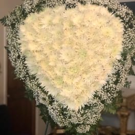 Heart-shaped white floral standing spray with baby's breath border