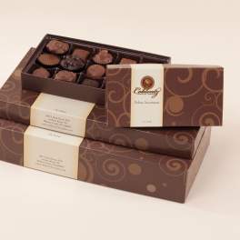 Stacked boxes of assorted chocolates with one open tray