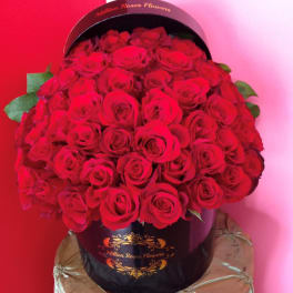 Large bouquet of red roses in a black hatbox