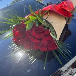 Bouquet of red roses wrapped in brown paper with red ribbon