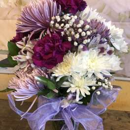 Purple and white bouquet with daisies, carnations, and alstroemeria tied with a lavender ribbon