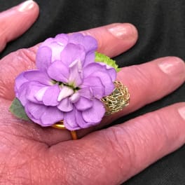 Small purple flower ring on a hand