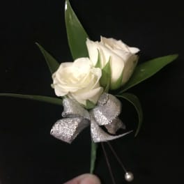 White rose boutonniere with a silver ribbon bow