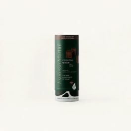 A cylindrical cocktail mixer container with dark green labeling