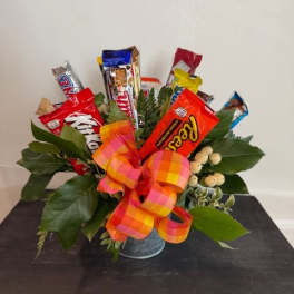 Candy bars arranged in a metal container with a plaid ribbon.