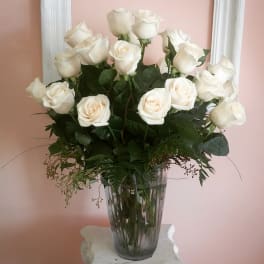 White roses arranged in a clear glass vase