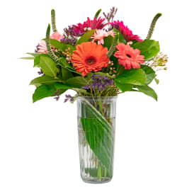 Mixed gerbera daisies in a clear glass vase