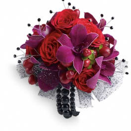 Red roses and purple orchids in a black mesh bouquet with bead accents
