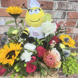 Bouquet with sunflowers and roses around a bee plush toy