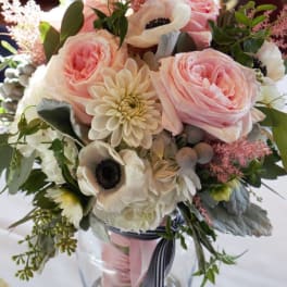 Pink and white bouquet in a glass vase with ribbon