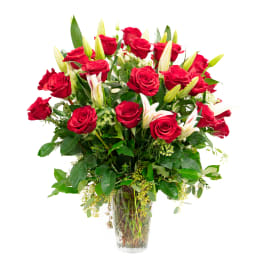 Red roses and white lilies arranged in a clear glass vase