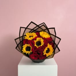 Bouquet of red roses and yellow sunflowers wrapped in black paper