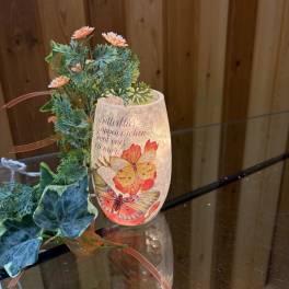 Butterfly-themed candle holder with faux flowers and ribbon