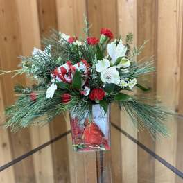 Holiday floral arrangement with red and white flowers in a decorative vase