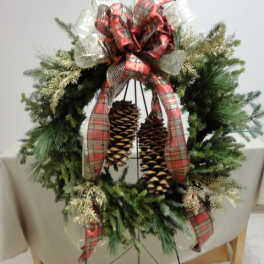Christmas wreath with plaid ribbon and hanging pinecones