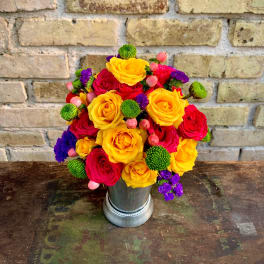 Bright bouquet of yellow and red roses in a silver vase