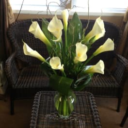 White calla lilies arranged in a clear glass vase