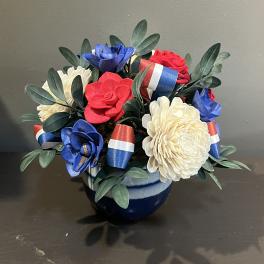 Arrangement of red, white, and blue flowers in a blue vase