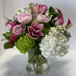 Pink and white floral arrangement in a clear glass vase