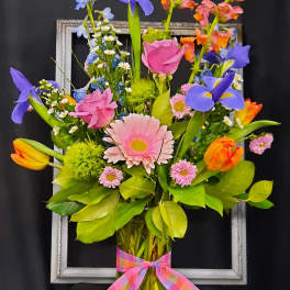 Colorful mixed bouquet in a glass vase with a plaid ribbon
